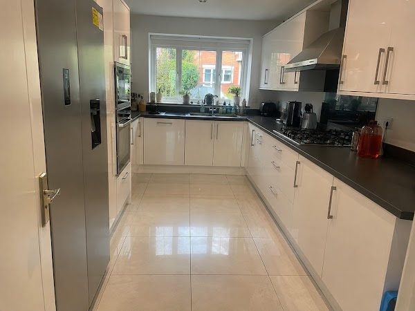 Gleaming white gloss kitchen with shining tiled floor